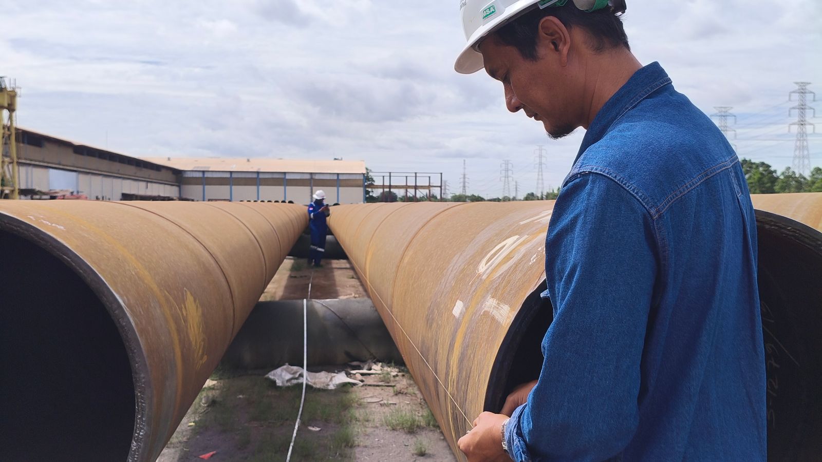 Construction professional inspecting large-diameter pipeline installation